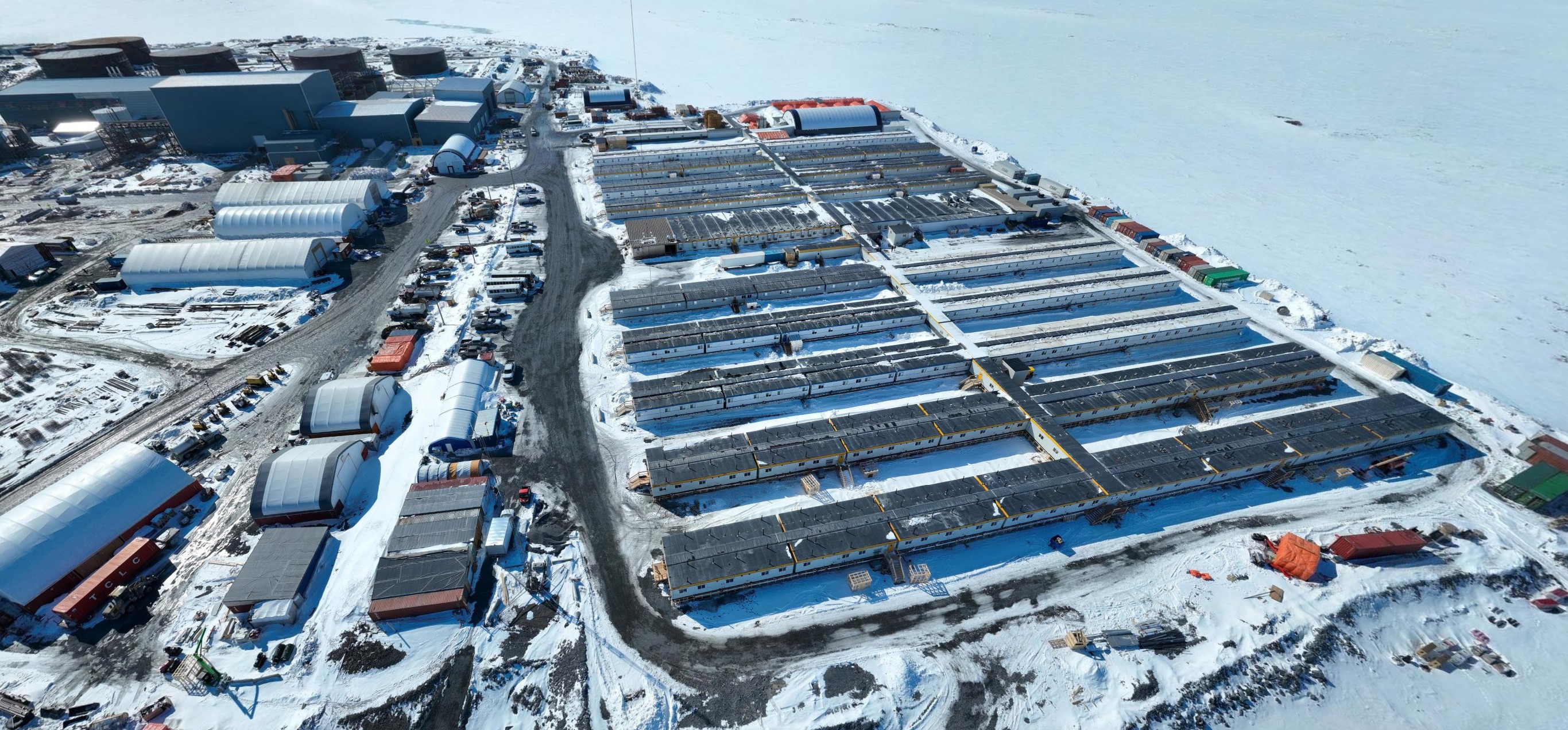 Aerial view of the accommodation complex at the Goose Project in Nunavut, with rows of modular units, containers, and construction materials.