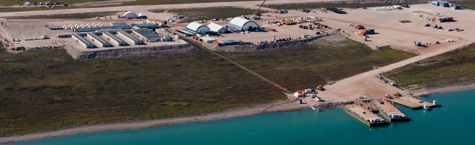 Aerial view of the Marine Laydown Area (MLA) at Bathurst Inlet, part of the Goose Project in Nunavut, with a barge unloading containers.
