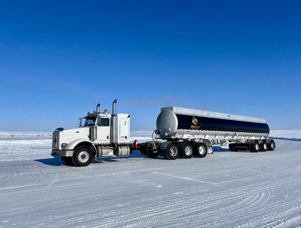 Large truck on winter ice road built for transporting materials to the Goose project site, with snow visible.