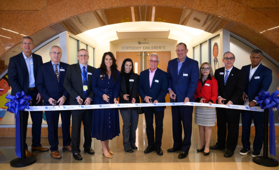 A group of people cutting a ribbon in official opening event
